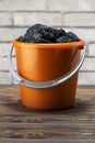 Coal pieces in the bucket on brick wall background. Royalty Free Stock Photo