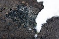 Coal shale layer in soil profile. Snow. Black charcoal texture background. Details on the surface of charcoal. Burning charcoal g