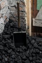 A coal shovel stuck in a pile of coalat the basement