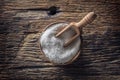 Coarse-grained salt in a wooden bowl with a ladle on an old oak table Royalty Free Stock Photo