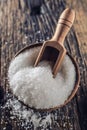 Coarse-grained salt in a wooden bowl with a ladle on an old oak table Royalty Free Stock Photo