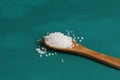 Coarse salt crystals on a blue table. Wooden spoon with sea salt.