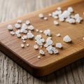 Coarse salt crystals scattered on a rectangular wooden cutting board with rounded Royalty Free Stock Photo
