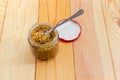 French mustard on spoon in glass jar on wooden surface Royalty Free Stock Photo