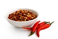 Coarsely ground chilli peppers in white ceramic bowl isolated on