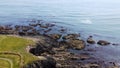 coast of the Atlantic Ocean in Ireland, top view. Rocky coast, seaside landscape. Irish nature. Green grass field on gray rocky