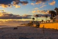 Coast of Daytona Beach in Florida at sunrise with people and palm trees Royalty Free Stock Photo