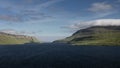 Coast of Faroe Islands with blue sky, green mountains and ocean at sunshine Royalty Free Stock Photo