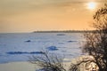 Coast of the frozen sea in winter, ice hummocks, reflection in the water of sun rays at sunset Royalty Free Stock Photo