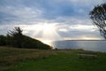 On the coast of Hundested. Sun rays break through the dramatic sky through the clouds Royalty Free Stock Photo