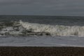 Coast line at Thyboron on the Danish west coast, clouds in the sky, waves in the sea, white foam splashes, rocks