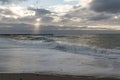 Coast line at Thyboron on the Danish west coast, clouds in the sky, waves in the sea, white foam splashes, rocks