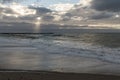 Coast line at Thyboron on the Danish west coast, clouds in the sky, waves in the sea, white foam splashes, rocks Royalty Free Stock Photo