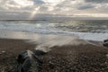 Coast line at Thyboron on the Danish west coast, clouds in the sky, waves in the sea, white foam splashes, rocks Royalty Free Stock Photo