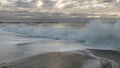 Coast line at Thyboron on the Danish west coast, clouds in the sky, waves in the sea, white foam splashes, rocks Royalty Free Stock Photo