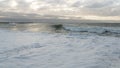 Coast line at Thyboron on the Danish west coast, clouds in the sky, waves in the sea, white foam splashes, rocks