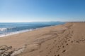 Coast line view with foot prints in the sand Royalty Free Stock Photo