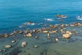 Coast rock beach and turquoise waters with gently waves.