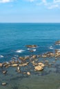 Coast rock beach and turquoise waters with gently waves.