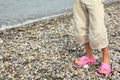 Coast of sea. legs of child with slippers