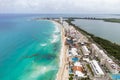 Coastal area. Many houses, green trees, bushes. On both sides of the coastal area there is an ocean with deep blue water. Light