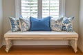 Coastal bench with patterned blue and white cushions by bedroom window Royalty Free Stock Photo