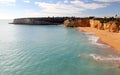 Coastal cliffs and sandy beach on sunny morning in Algarve, Armacao de Pera, Portugal Royalty Free Stock Photo