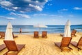 Coastal landscape - man saunter along the sea against the background beach umbrellas and loungers Royalty Free Stock Photo