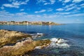 Coastal landscape - the rocky seashore with houses under the sky with clouds Royalty Free Stock Photo