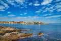 Coastal landscape - the rocky seashore with houses under the sky with clouds Royalty Free Stock Photo