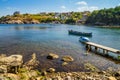 Coastal landscape - the wooden pier and boats in rocky bay