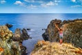 Coastal rocky landscape - the girl hands raised up to sky celebrating freedom Royalty Free Stock Photo