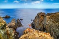 Coastal rocky landscape - the girl hands raised up to sky celebrating freedom Royalty Free Stock Photo