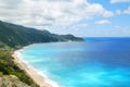 Coastal sea blue waters with beach and steep hill