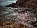 Coastal seascape, tide coming in over a rocky beach.