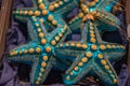 Coastal style Christmas ornaments closeup. Glass Christmas baubles in shape of sea stars blue painted with yellow dots. Royalty Free Stock Photo