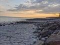 Coastal Sunset: a Serene Nature Scene of Ocean Waves, Beach Rocks, and Colorful Sky Royalty Free Stock Photo