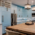 A coastal-themed kitchen with light blue cabinets, beachy backsplash tiles, and a farmhouse sink4, Generative AI