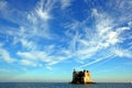 Liguria: coastal tower at sea under a cloudy sky view from the boat Royalty Free Stock Photo