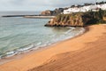 Coastal view of Albuferia in the Algarve region of Portgual, showing the beach, cliffs and jetty Royalty Free Stock Photo