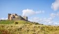 Coastal view of Bamburgh Castle rising from the sand dunes at Bamburgh, Northumberland, UK Royalty Free Stock Photo