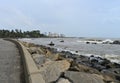 Coastal view of the rocks stacked as a dam, a fisherman fishing in the background