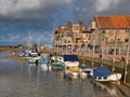 The coastal village of Blakeney on the North Norfolk Coast. Leisure boats are moored at the quayside on a sunny day in summer