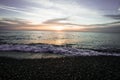 Coastal waves at sunset. Colorful sunset on a sea beach.