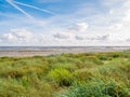 Coastline with dunes, beach and boat dried out on sand flats of