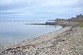 Coastline with pebbles & boulders and the Sandsayre Pier on a grey summer day, Sandwick, Shetland Islands, Scotland