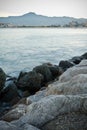 Coastline rocks in satin soft atlantic ocean, mountain trois couronnes at sunset in long exposure, basque country, france