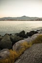 Coastline rocks in satin soft atlantic ocean, mountain trois couronnes at sunset in long exposure, basque country, france