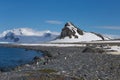 Coastline with stones and ice, sea lagoon with mountains with colony of antarctica chinstrap penguin. Half Moon island