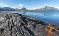 The coastline of Vestfjord of Lofoten archipelago with the textured stone at foregrund. The mountain landscape of Austvagoya